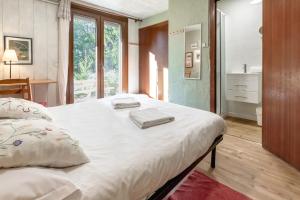 1 dormitorio con 1 cama grande y 2 toallas. en Clos de l'Ours - 2 chambres - Jardin privé, en Chamonix-Mont-Blanc
