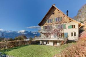 a large house on a hill with a grass yard at Le Petit Eloi in Saint-Gervais-les-Bains