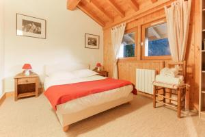 a bedroom with a bed and a chair and a window at Chalet Ancelles - Les Praz - Golf - Vue Mont-Blanc - Randonnées in Chamonix-Mont-Blanc