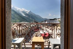 d'un balcon avec une table, des chaises et une montagne. dans l'établissement Nook 42 - The Loft - Central 2br w/ Balcony Views, à Chamonix-Mont-Blanc