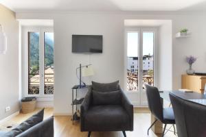 - un salon avec un canapé, une table et des chaises dans l'établissement Nook 42 - The Loft - Central 2br w/ Balcony Views, à Chamonix-Mont-Blanc