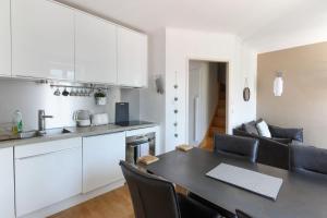 Il comprend une cuisine, un salon et une salle à manger avec une table. dans l'établissement Nook 42 - The Loft - Central 2br w/ Balcony Views, à Chamonix-Mont-Blanc