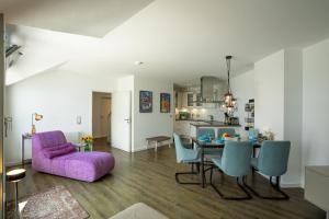a living room with a purple couch and a table at Turm-Appartement Strandburg in Fehmarn