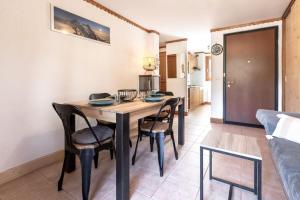 eine Küche und ein Esszimmer mit einem Holztisch und Stühlen in der Unterkunft Sapins 11 - Appartement familial - Pied des pistes - Vue sur les montagnes in Les Chavants + 16 Fotos