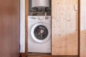 eine Waschmaschine und ein Trockner in einem kleinen Raum in der Unterkunft Sapins 11 - Appartement familial - Pied des pistes - Vue sur les montagnes in Les Chavants