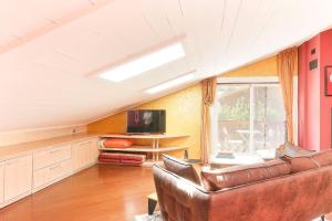 a living room with a couch and a television at Appartement Yoga - Vues Chaîne du Mont-Blanc - Calme - Espace Yoga Spacieux in Les Trabets