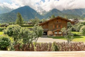 a house in a field with mountains in the background at Appartement Yoga - Vues Chaîne du Mont-Blanc - Calme - Espace Yoga Spacieux in Les Trabets