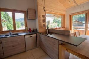 a kitchen with a counter top and two windows at Le Lac - Servoz - Appartement paisible de 70m² in Les Houches +11 photos