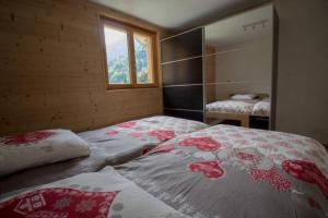 a bedroom with a bed with a flower pattern on it at Le Lac - Servoz - Appartement paisible de 70m² in Les Houches