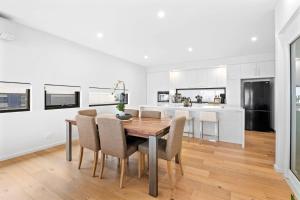 Una cocina y un comedor con mesa y sillas de madera. en Oceania 8, en Lorne