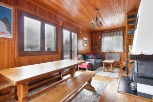 een woonkamer met een houten tafel en een bank bij The Historic Chalet Les Allognes Mont-Blanc views in Les Trabets