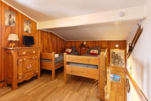 1 dormitorio con 1 cama y TV. en The Historic Chalet Les Allognes Mont-Blanc views, en Les Houches