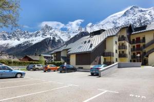 - un parking en face d'un bâtiment avec des montagnes enneigées dans l'établissement Le Petit Cocon, aux Houches