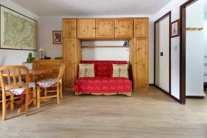 - une chambre avec un lit rouge, une table et des chaises dans l'établissement Le Petit Cocon, aux Houches