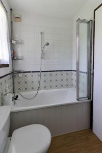 La salle de bains est pourvue d'une douche, d'une baignoire et de toilettes. dans l'établissement Le Petit Cocon, aux Houches