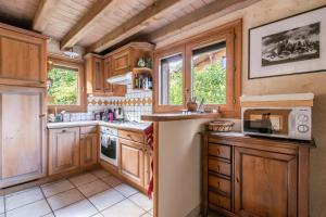 a kitchen with wooden cabinets and a sink and a microwave at Les Cristalliers - Cozy family chalet - Close to the village in Les Houches