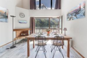 uma sala de jantar com uma mesa de madeira e cadeiras em Le Crêtet Mont-Blanc em Chamonix-Mont-Blanc
