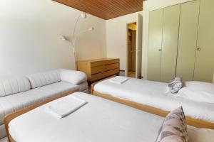 um pequeno quarto com 2 camas e um sofá em Le Crêtet Mont-Blanc em Chamonix-Mont-Blanc