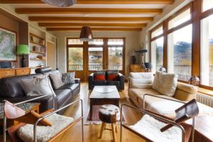 ein Wohnzimmer mit einem Sofa, Stühlen und Fenstern in der Unterkunft Saint Éloi - Panoramic view - Mont Joly - Central in Saint-Gervais-les-Bains