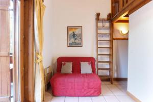 a red ottoman sitting in a room with a ladder at Le Goûter - Ski-in ski-out - Indoor Pool in Les Houches