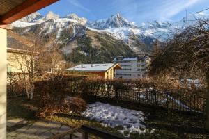 Les Alpins - Centre de Chamonix - Rénové avec Jardin et vue imprenable sur le MontBlanc في شامونيه مون بلان: اطلالة على سلسلة جبلية مع ثلج