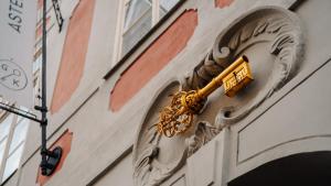 un objet en or sur le côté d'un bâtiment dans l'établissement Hotel Golden Key Prague Castle, à Prague
