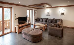 uma sala de estar com um sofá e uma televisão em Les Ecureuils -Rénové 100m2 - 8per - Skis aux Pieds - Vue sur la Montagne em Les Houches