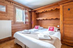 a bedroom with two beds in a room with wooden walls at Le Petit Paradis - Indoor pool and sauna in Chamonix-Mont-Blanc +15 photos