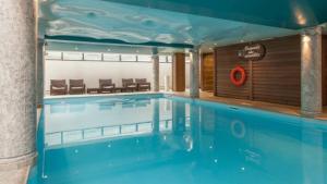 a large swimming pool in a building with a pool at Le Petit Paradis - Indoor pool and sauna in Chamonix-Mont-Blanc