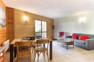 ein Wohnzimmer mit einem Tisch und einem Sofa in der Unterkunft Les Granges des Bossons in Chamonix-Mont-Blanc