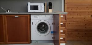 eine Waschmaschine mit einer Mikrowelle darüber in der Unterkunft Les Granges des Bossons in Chamonix-Mont-Blanc