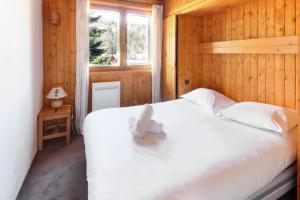 a bedroom with a bed with a stuffed animal on it at Chalet Charousse in Les Houches
