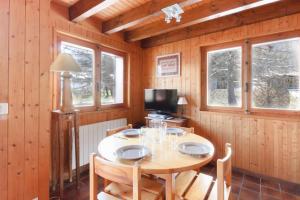 a wooden dining room with a table and chairs at Chalet Charousse in Les Houches