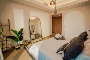 a bedroom with a large bed and a mirror at Private Pool & Beach At Your Doorstep in Abu Dhabi