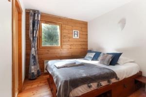 a bedroom with a bed in a wooden room at Le Grand Tetras - Beside Lake Chavants, TMB staring point & Hikes in Les Houches