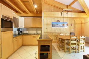une cuisine avec des armoires en bois et une table en bois dans l'établissement Le Quatre - 75m2 Charmant Duplex - Central - 8-10 pax 3ch, à Saint-Gervais-les-Bains