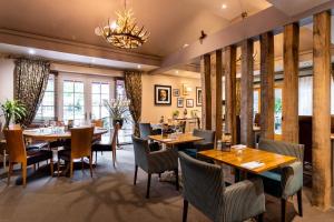 um restaurante com mesas e cadeiras e um lustre em The Dewdrop Inn em Worcester