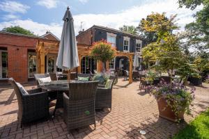 un patio con una mesa con sombrilla y sillas en The Dewdrop Inn en Worcester