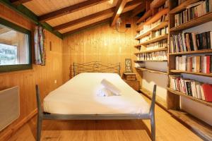 a bedroom with a bed in a room with bookshelves at Chalet of the 5 Chardons ski-in ski-out in Les Houches