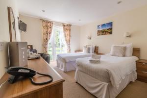 een hotelkamer met 2 bedden en een telefoon bij The Dewdrop Inn in Worcester