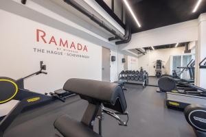 een fitnessruimte met loopbanden en hometrainers. bij Ramada The Hague Scheveningen in Scheveningen