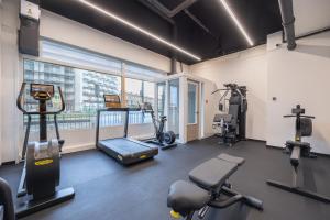 einen Fitnessraum mit Laufbändern und Trainingsgeräten in einem Gebäude in der Unterkunft Ramada The Hague Scheveningen in Scheveningen