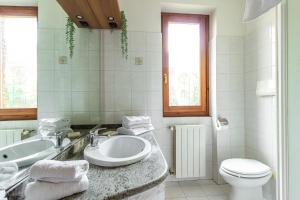 bagno bianco con lavandino e servizi igienici di Como Lake, Milan & Railway station - Self ck-in & access a Fino Mornasco