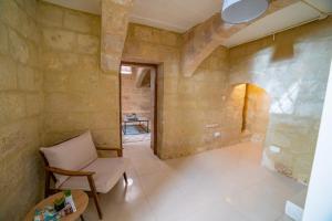 ein Wohnzimmer mit einem Stuhl und einem Tisch in der Unterkunft Carmelita Maisonette Valletta in Valletta