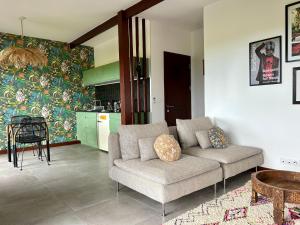 Il comprend un salon avec un canapé et une cuisine. dans l'établissement Kaz C2C - Une maison Balinaise avec jacuzzi, à Saint-Pierre