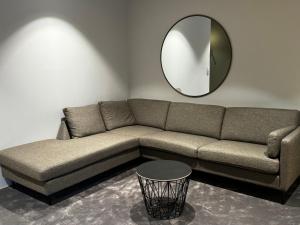 a living room with a couch and a mirror at North Apartment City house. in Tromsø