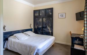 une chambre avec un grand lit et une tête de lit bleue dans l'établissement Logis Hotel Le Provencal, aux Issambres