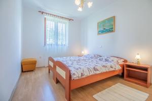 a bedroom with a bed and a table and a window at Apartments Antica with a balcony in Baška