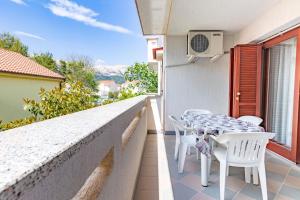 a balcony with a table and chairs on a wall at Apartments Antica with a balcony in Baška