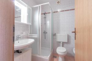 a bathroom with a toilet and a sink and a shower at Apartments Antica with a balcony in Baška +7 photos